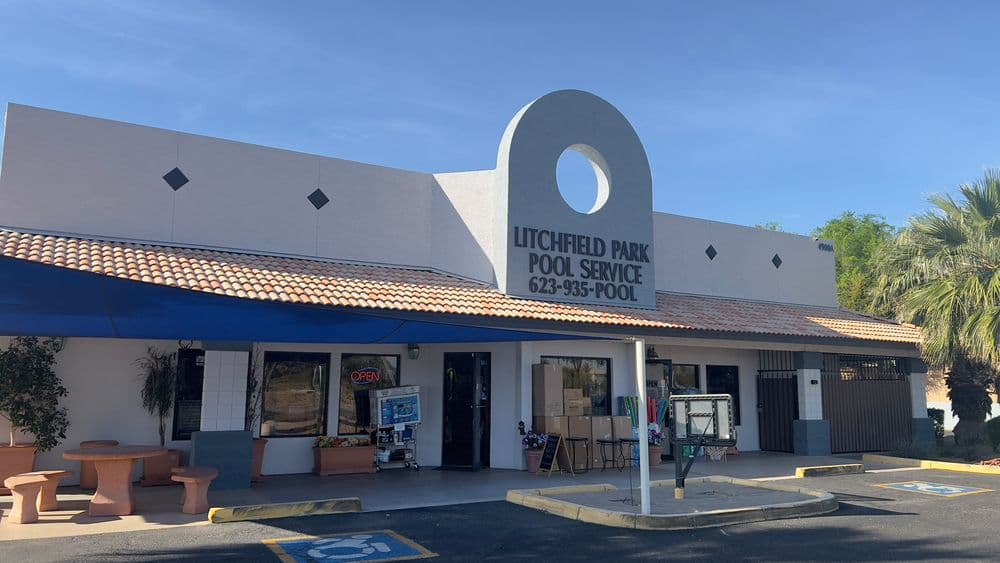 Litchfield Park Pool Service storefront with signage and outdoor seating on a sunny day.