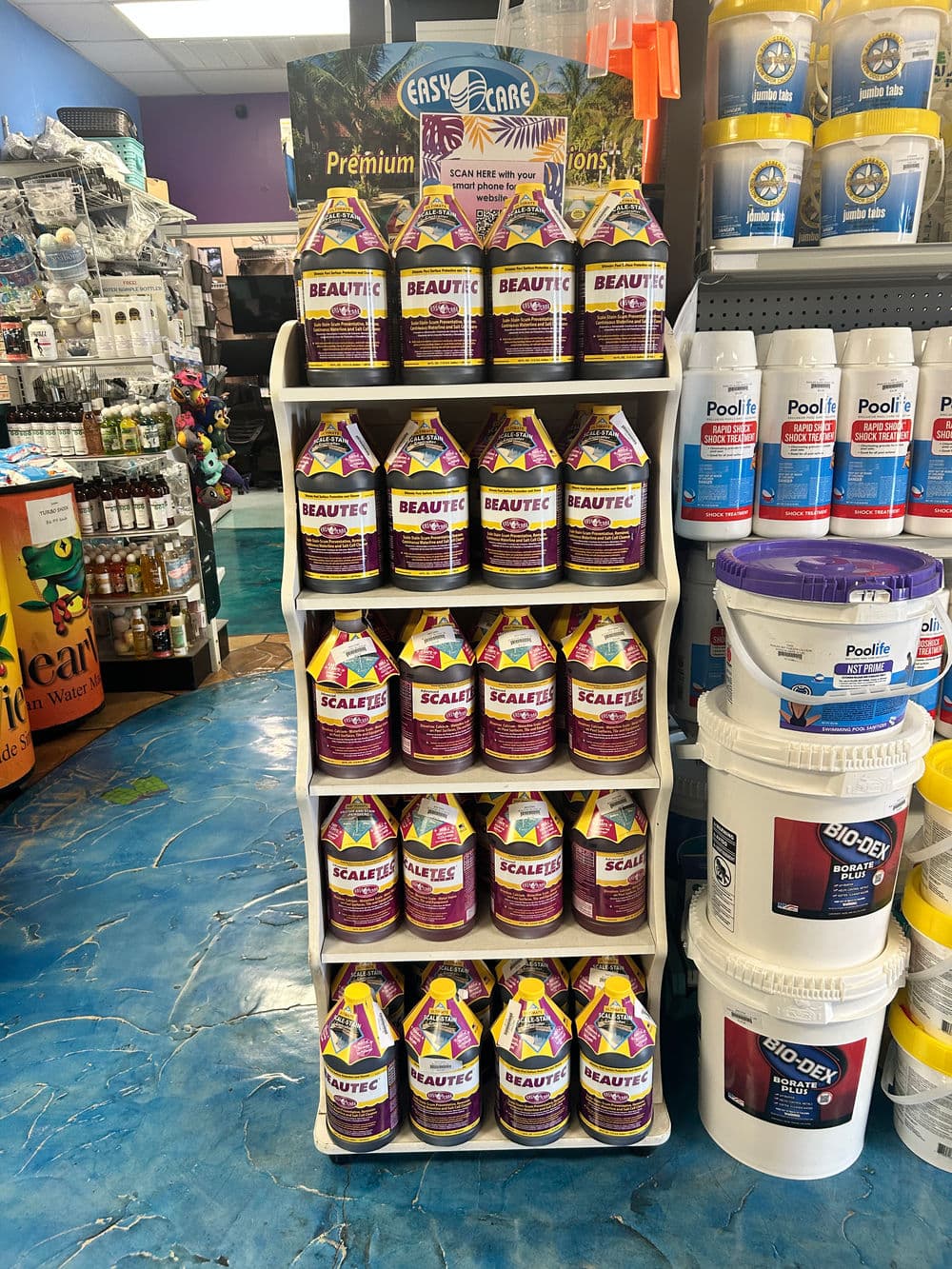 Display of Beautec and Scalatec pool care products on a retail shelf in a vibrant store.